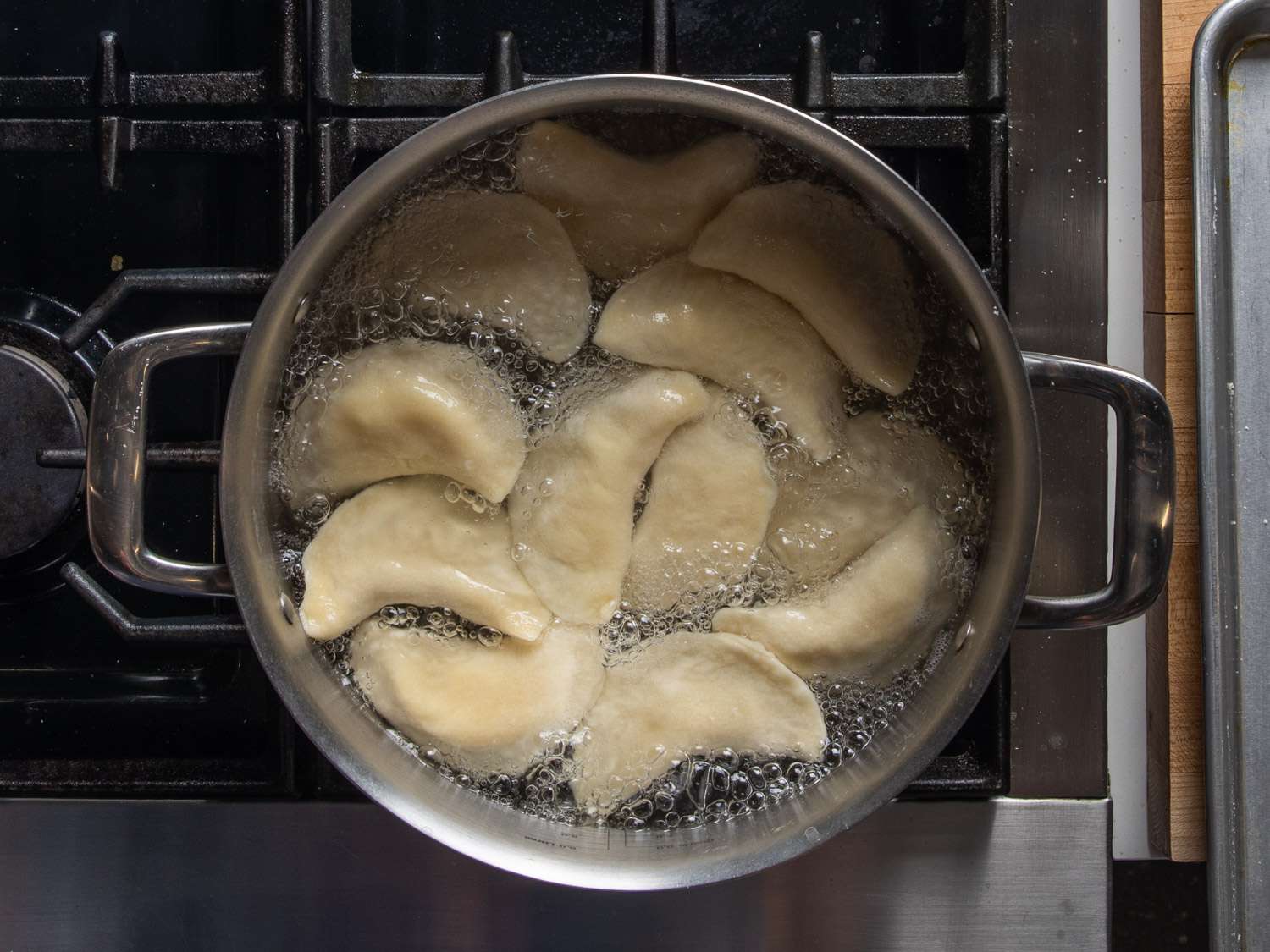 Pierogi cooking in a pot of boiling water.