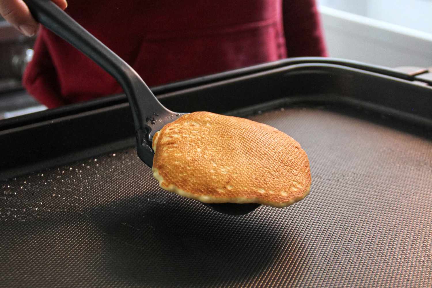 A person using the GIR Premium Silicone Mini Flipper to flip food