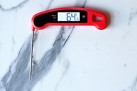 The Lavatools thermometer with its probe out on a marble countertop.