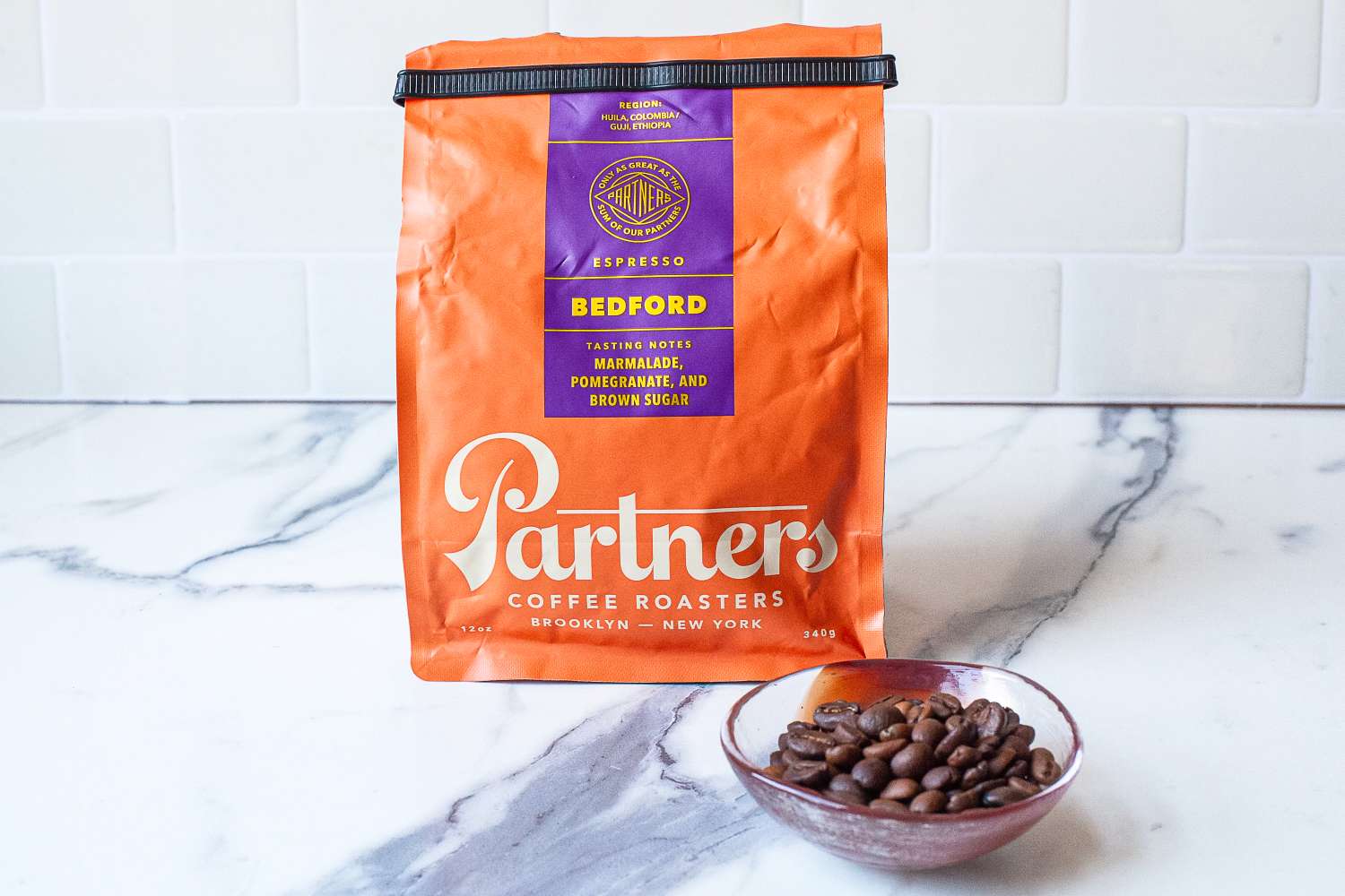 A package of Partners Coffee Bedford espresso with a bowl of coffee beans