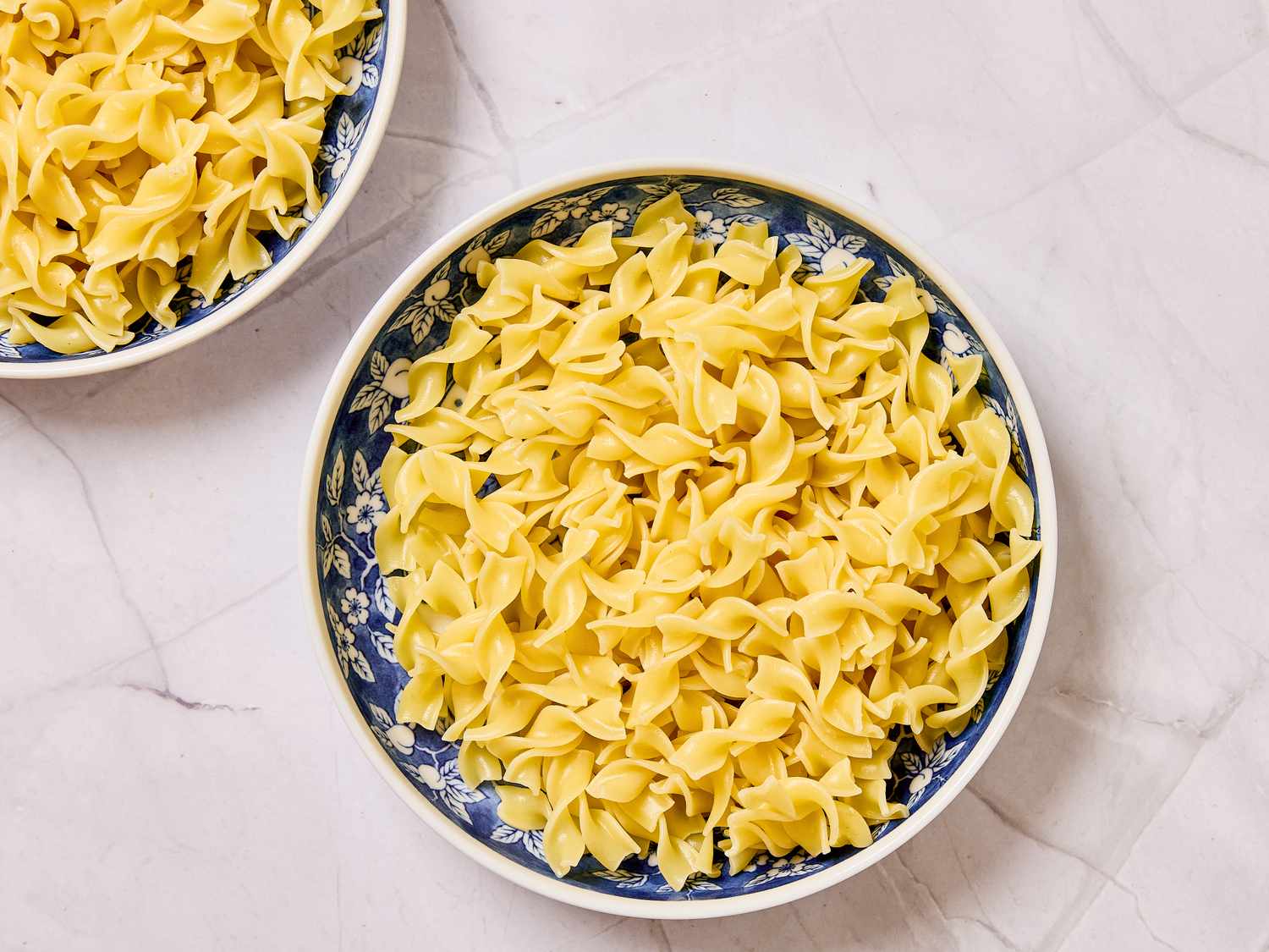A bowl of cooked egg noodles on a countertop