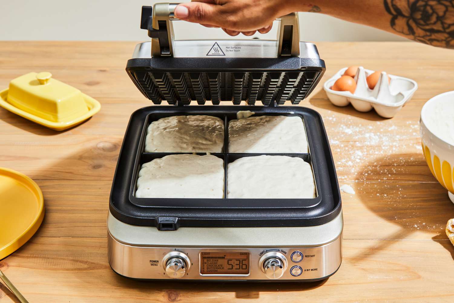 Person opening Breville The Smart Waffle Pro 4-Slice Waffle Maker