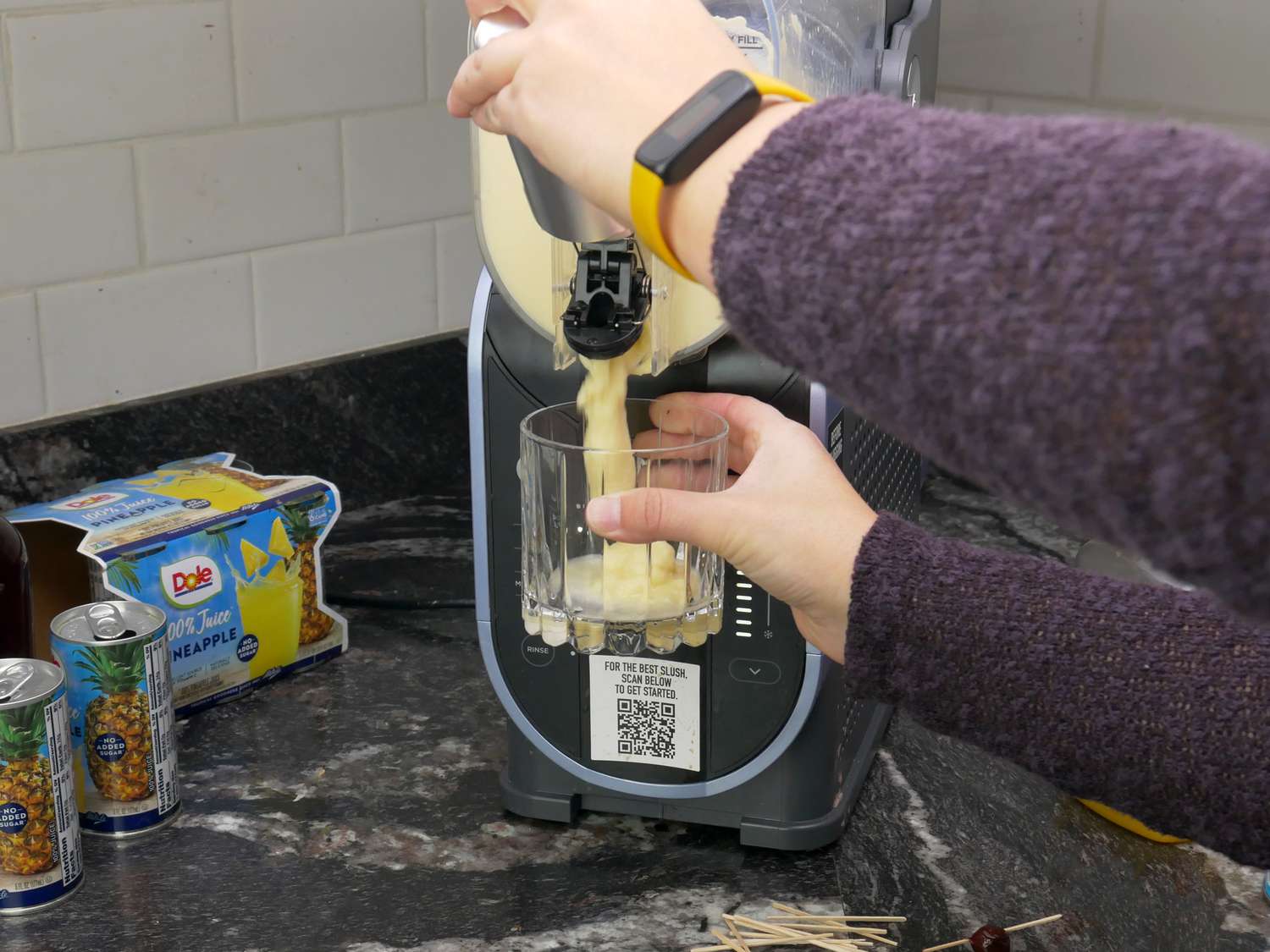 a person dispensing a frozen cocktail from the ninja