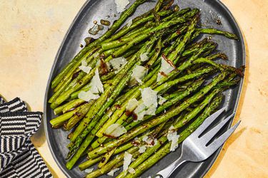 Overhead view of air-fryer asparagus, served on an oblong, slate colored platter.