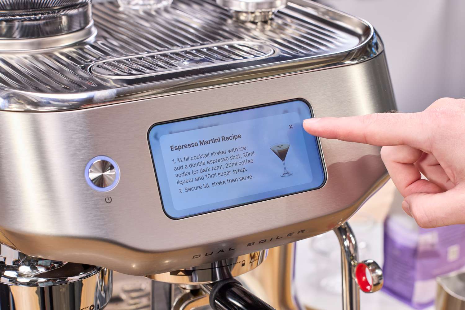 A person presses the touchscreen on the Breville The Oracle Dual Boiler Espresso Machine
