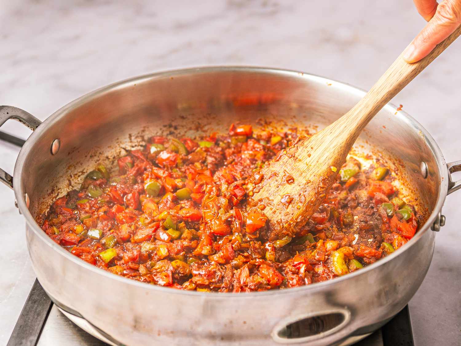 Side view of stirring meat into pan