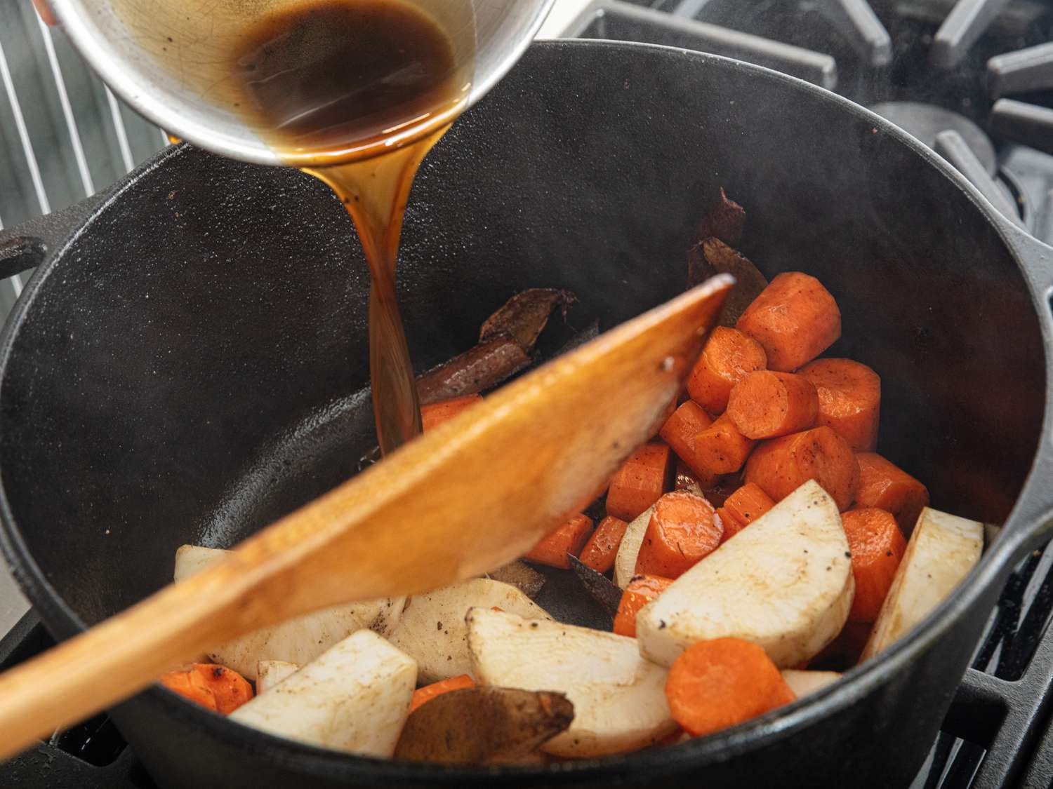mixing liquids into cooking vegatables in pot 