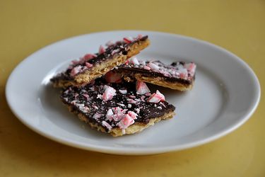 A plate holding three pieces of peppermint bark.