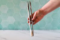 Hand holding the Material Kitchen The Only Tongs