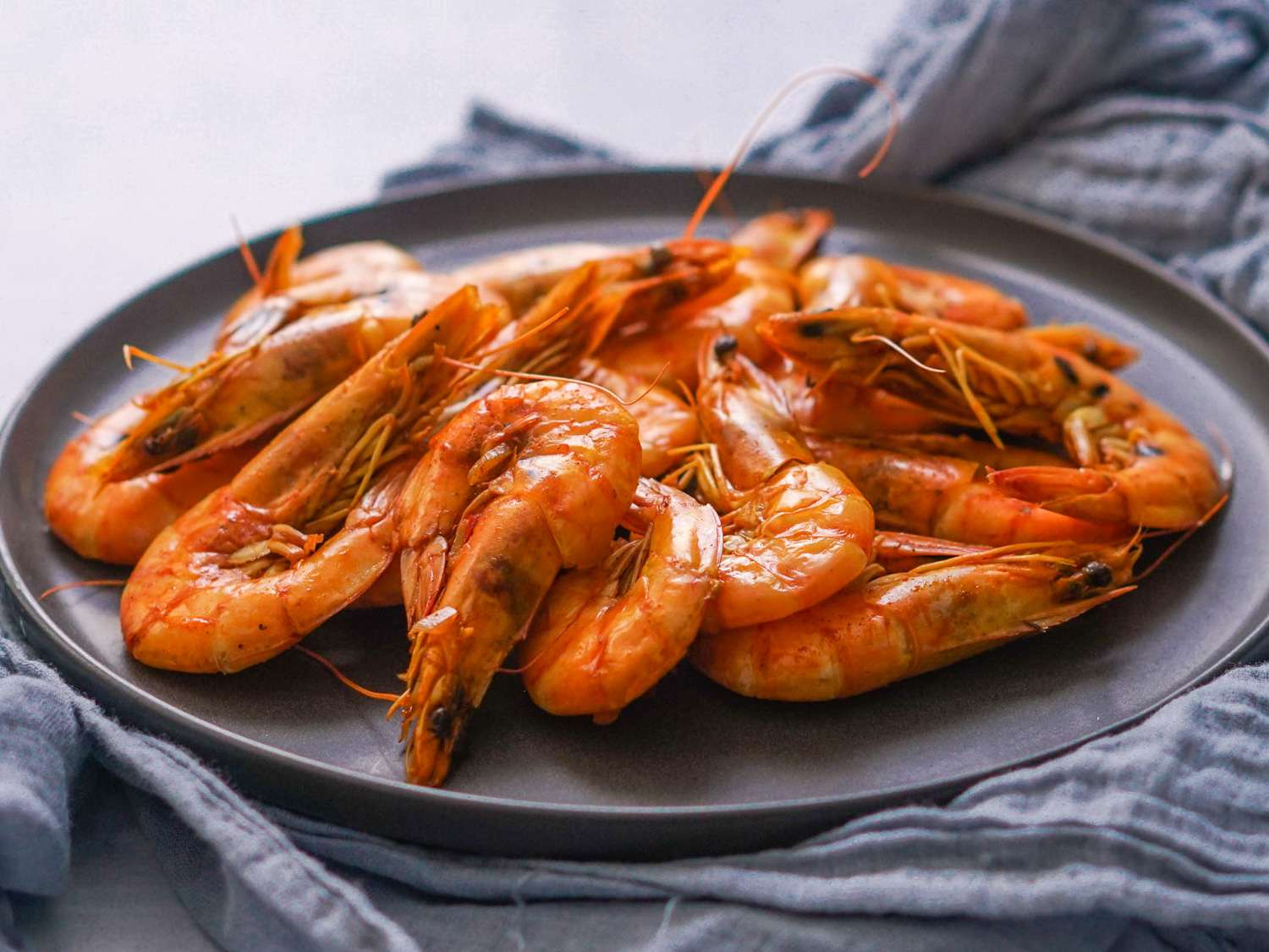 Cooked Jamaican pepper shrimp resting on a black plate.