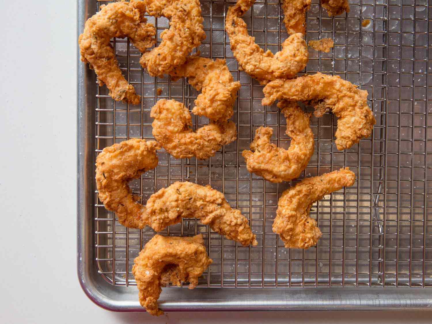 Closeup overhead shot of fried shrimp on a wire rack.