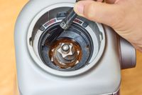 A person uses a brush to clean the Breville The Smart Grinder Pro