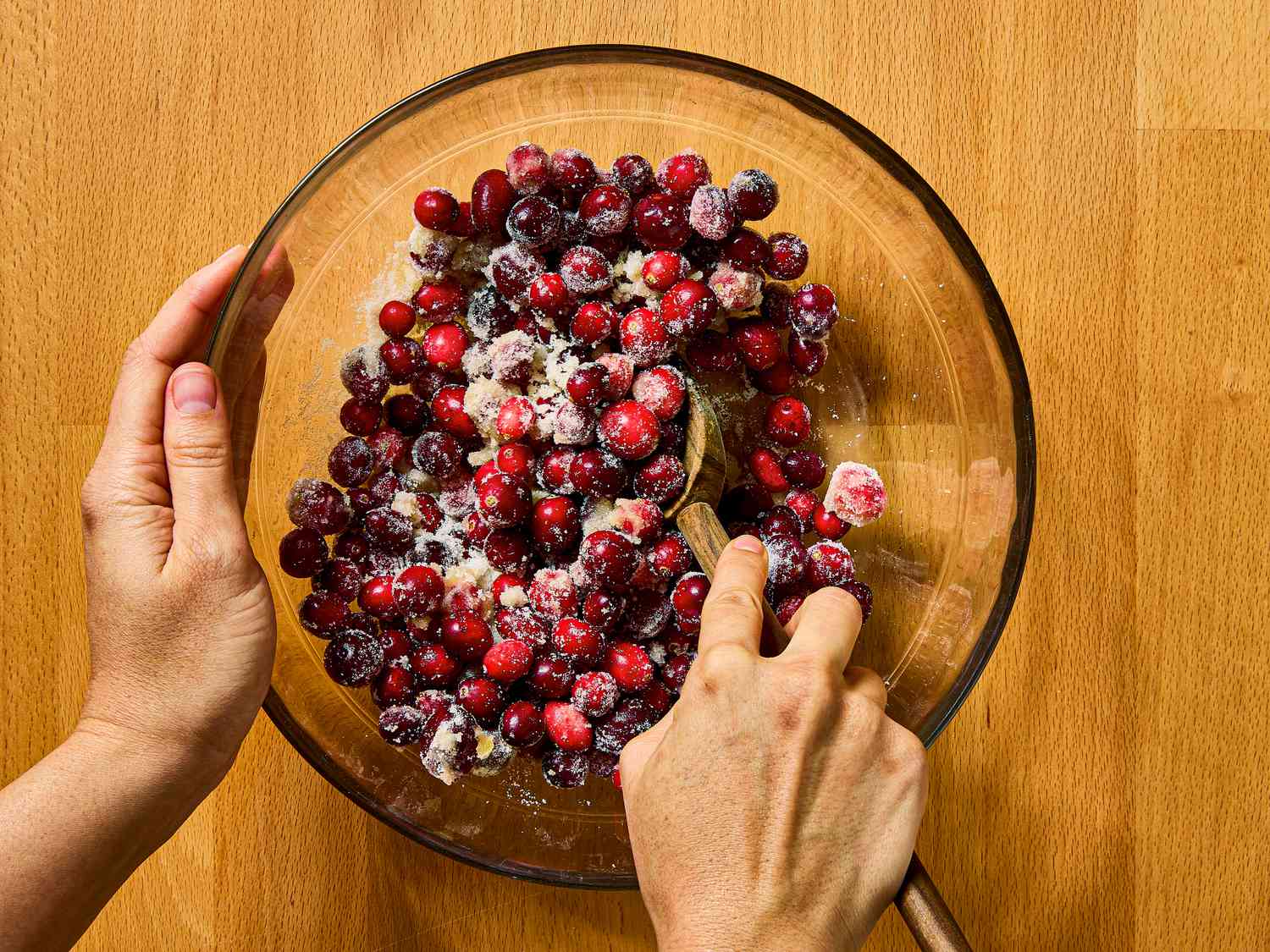Overhead of mixing cranberries with wooden spoon