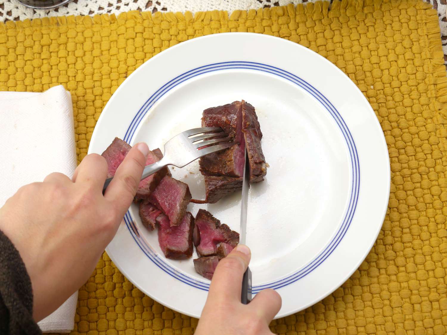 a person using the zwilling steak knife to slice steak