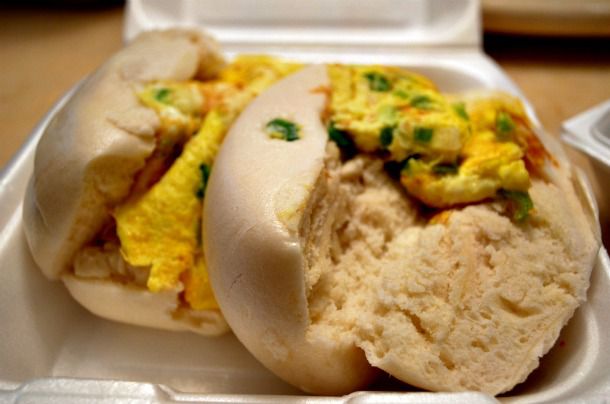Two mantou with scrambled egg filling, served in a to-go container.