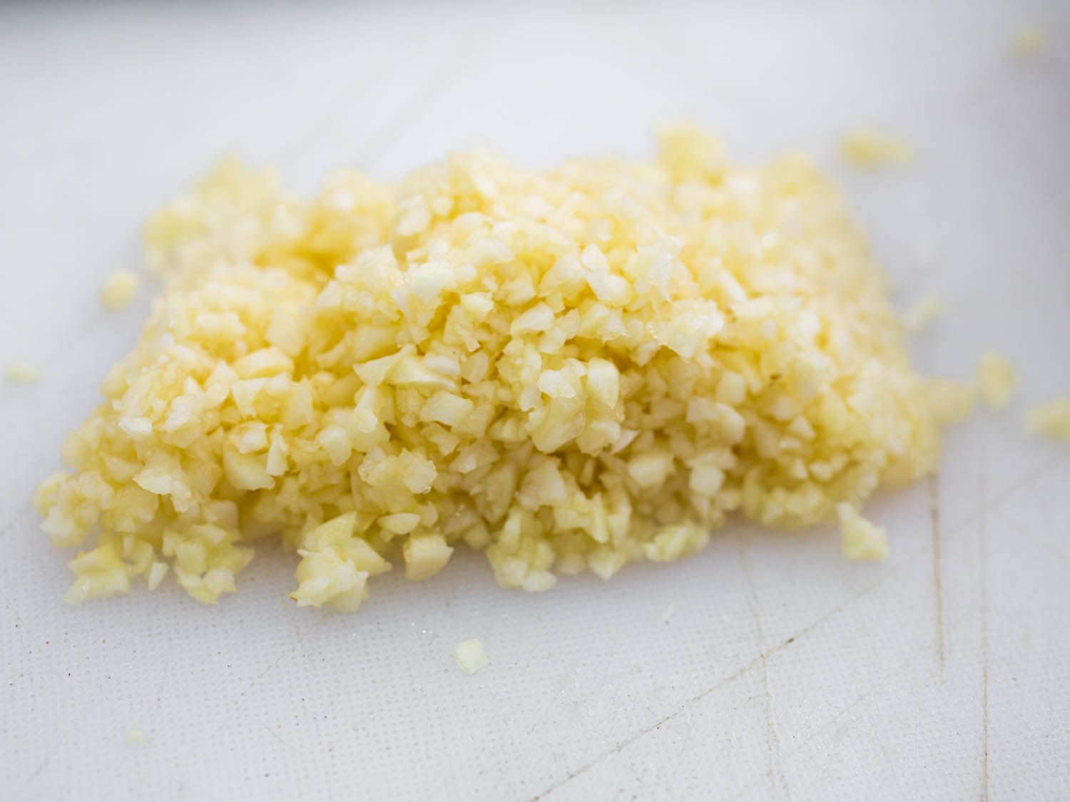 A pile of garlic, minced by hand into very small pieces.