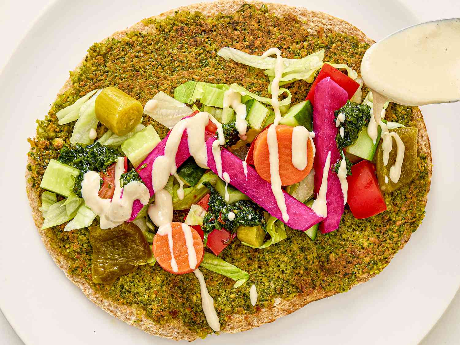 A smash falafel pita with toppings. 