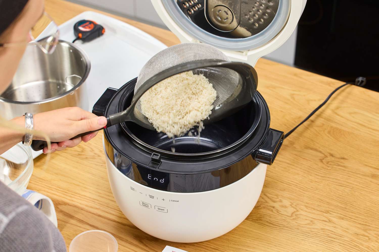 A person pours rice into the Instant Pot 20 Cup Multigrain Cooker