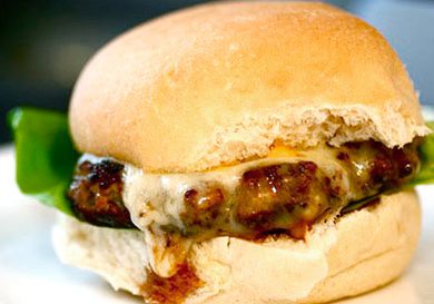 Turkey burger topped with melted cheddar cheese resting on a burger bun.