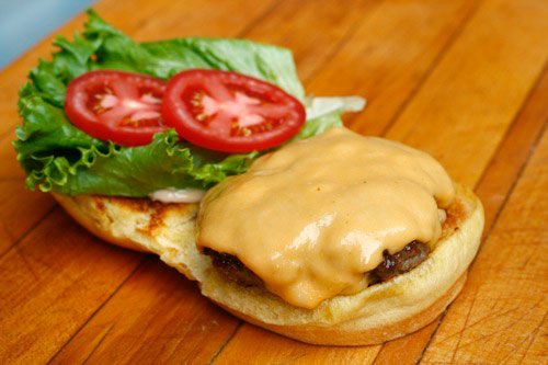 A topped and garnished fakeshack burger, ready to be closed.