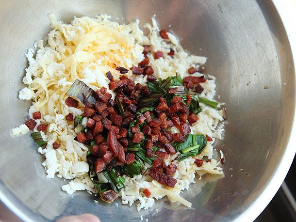 Cooked ramps and chorizo with cheese in a metal bowl.