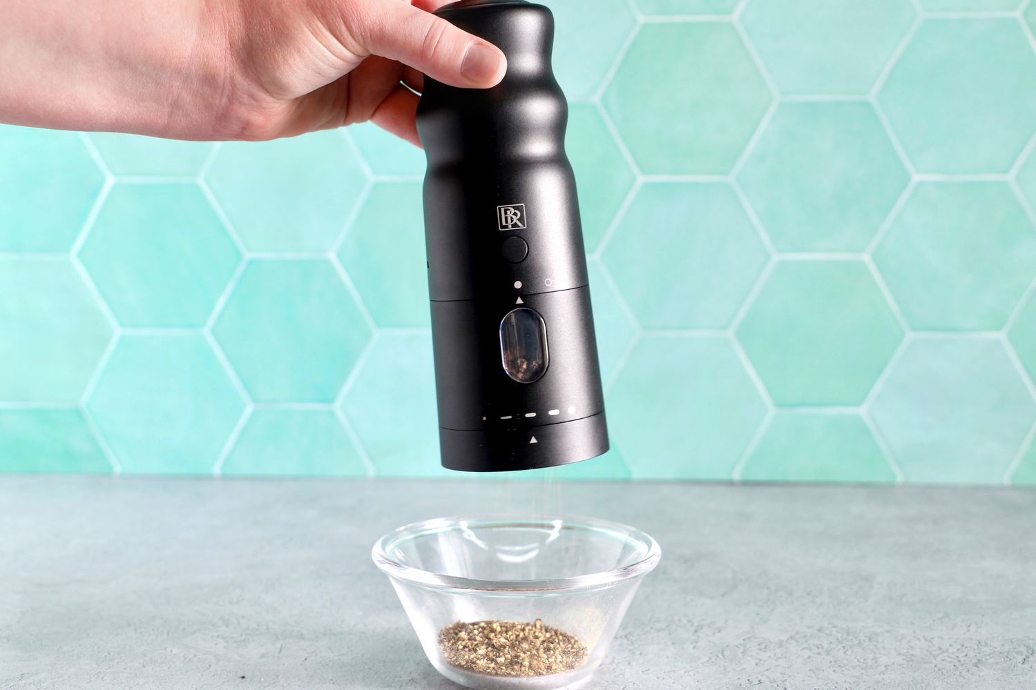 a person using the black rain pepper mill