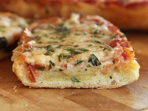 Close up of French bread pizza finished with cheese and herbs.