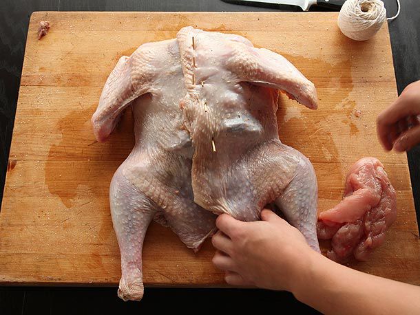 Closing up the stuffed turkey with skewers 