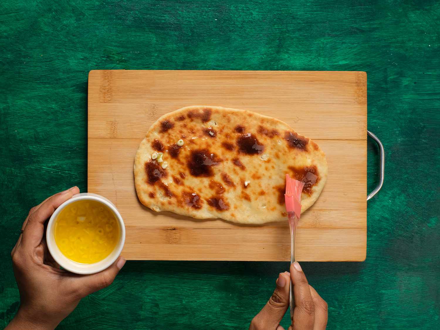 Brushing garlic naan with melted butter 