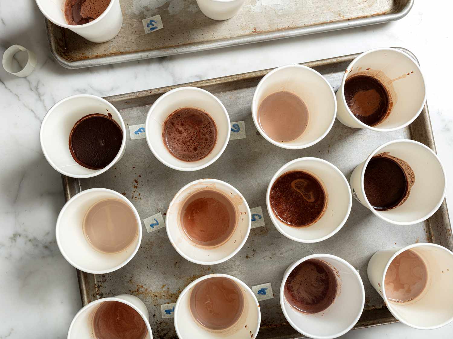 Rows of many different types of hot chocolate in small cups lined up with numbers next to them 