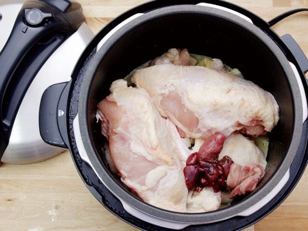 Uncooked chicken added to pressure cooker.