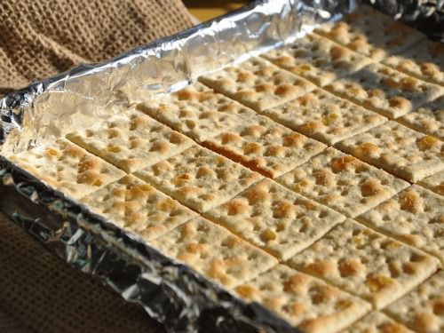 A foil-lined tray with squares of saltine crackers.