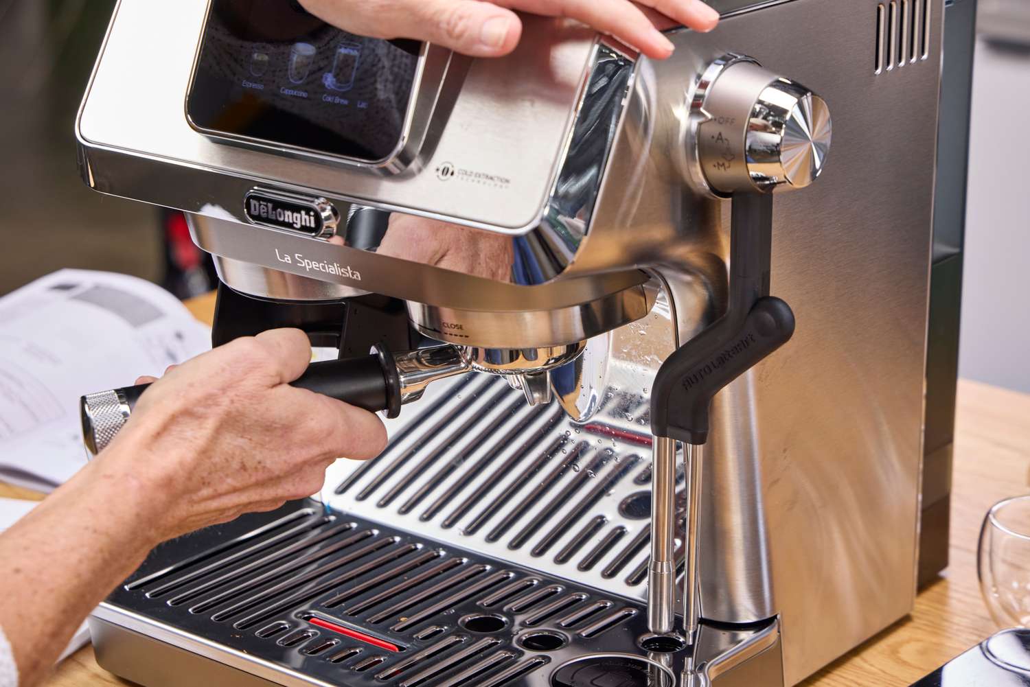 A person adds ground espresso to the De'Longhi La Specialista Touch Espresso Machine