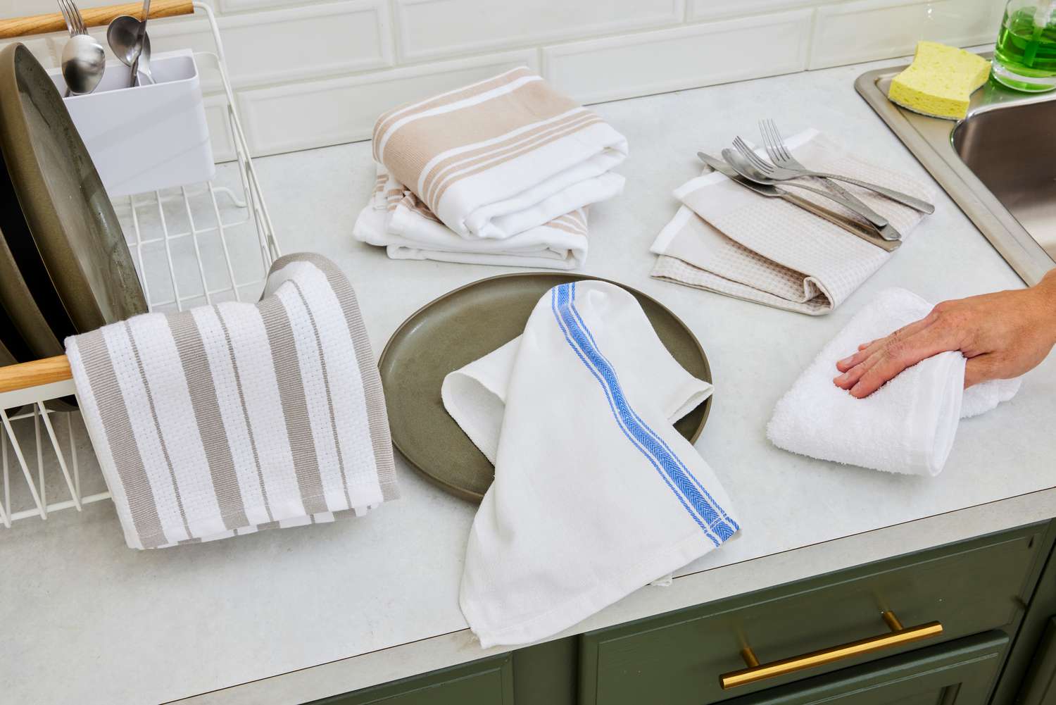 Numerous kitchen towels on a kitchen countertop.