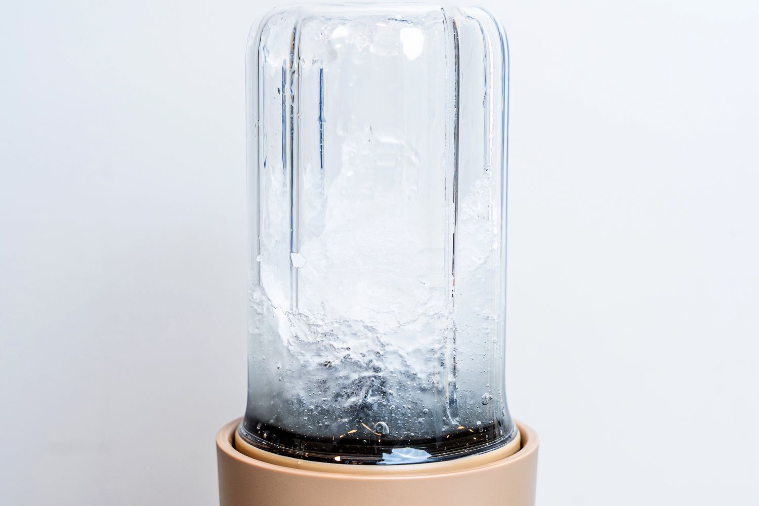 A blender in operation with ice being crushed inside its transparent container
