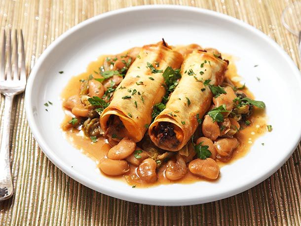 A plate of Sweet Potato and Mushroom Cannelloni, served atop Braised Escarole and Butter Beans.
