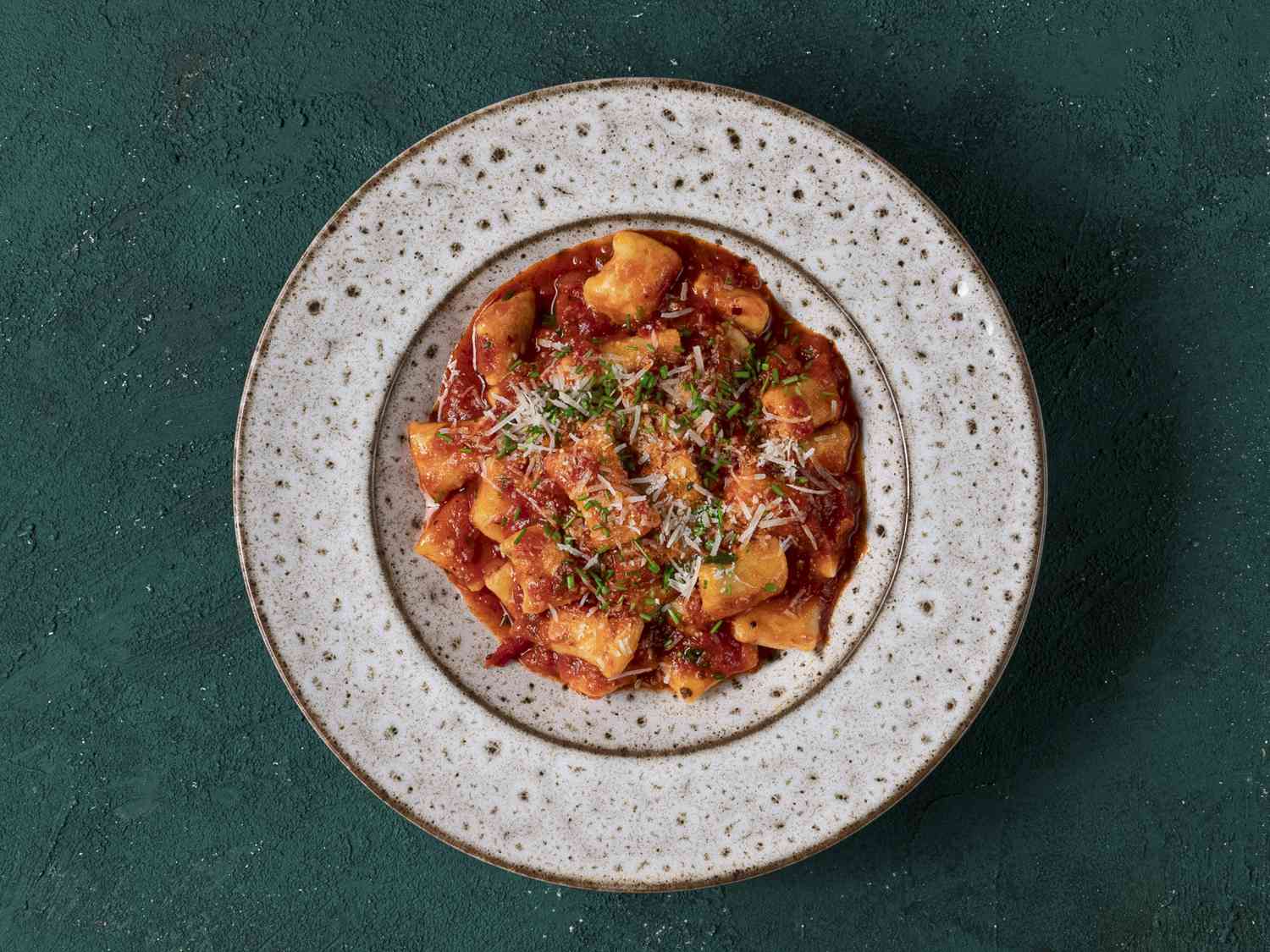 Ricotta gnocchi in tomato sauce on a ceramic plate.