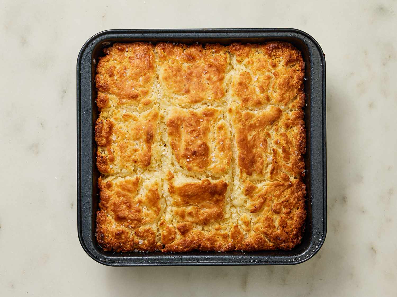 Baked bisquits in square pan on marble surface 