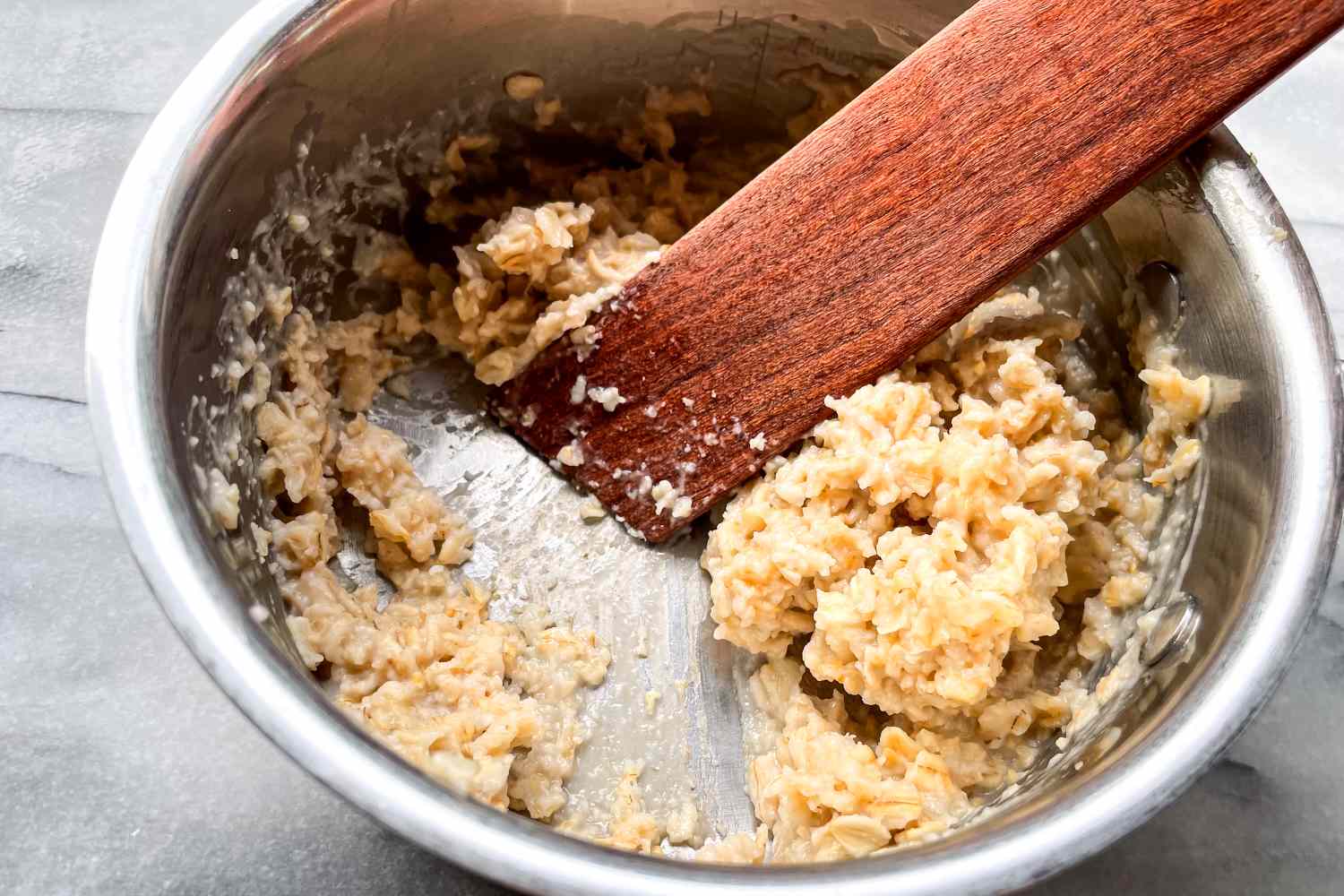 A bowl with a wooden spoon and a mixture of oats and other ingredients