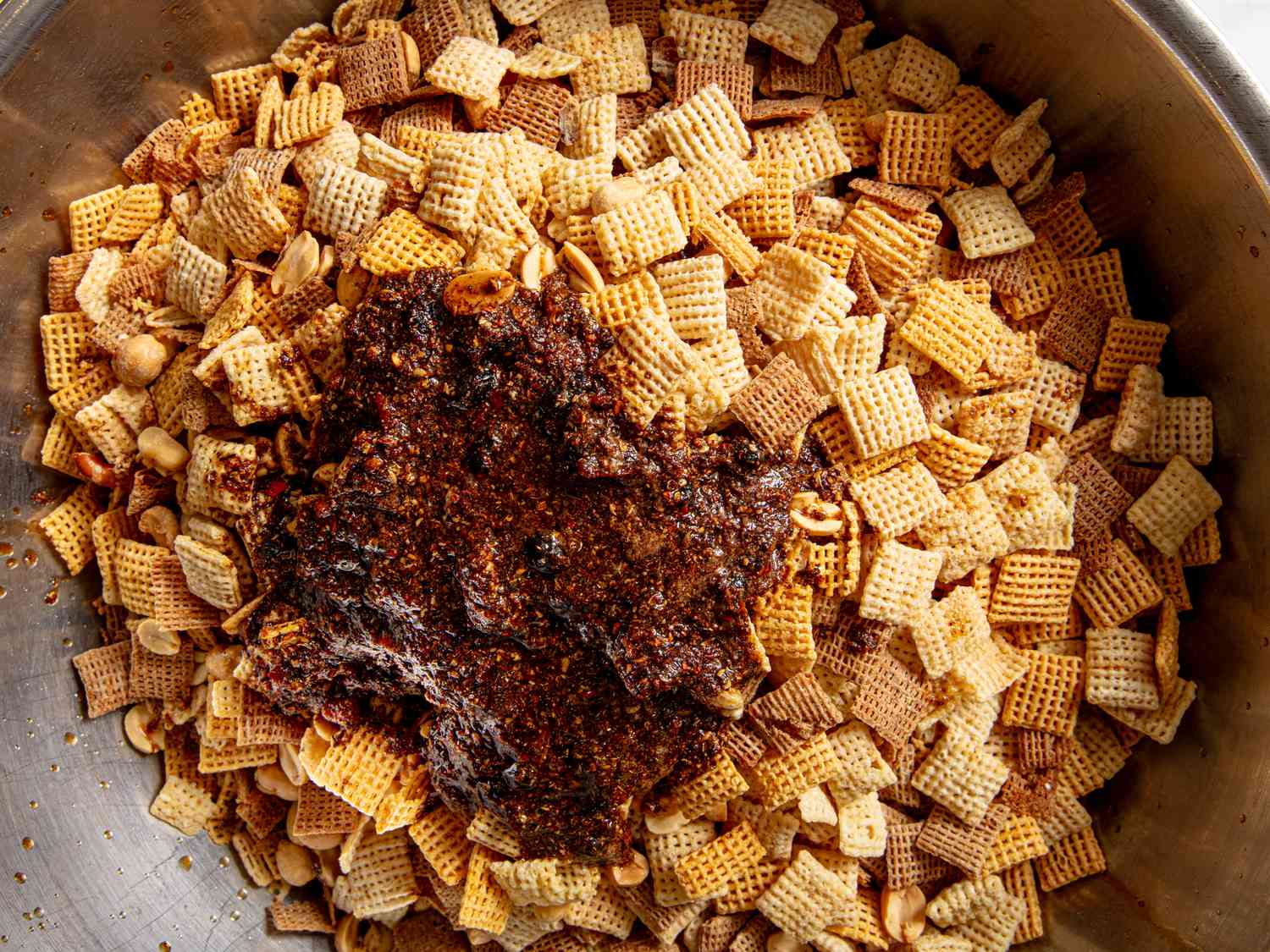 Overhead view of mala spiced sauce and chex mix before mixing