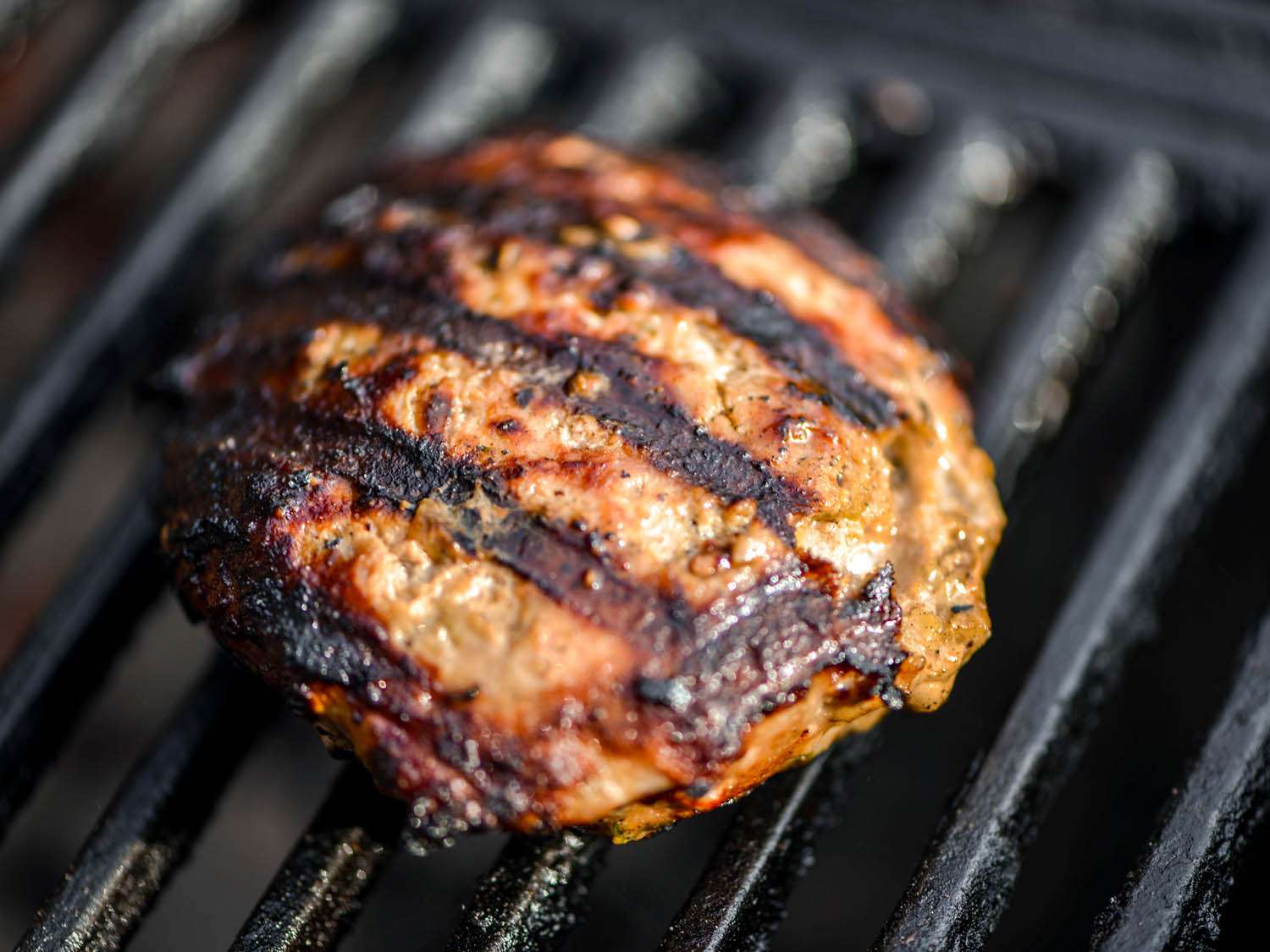 Grilling turkey burger patty.