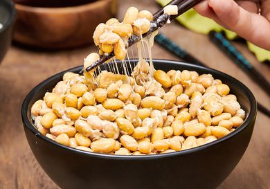 Side angle view of natto being picked up with chopsticks