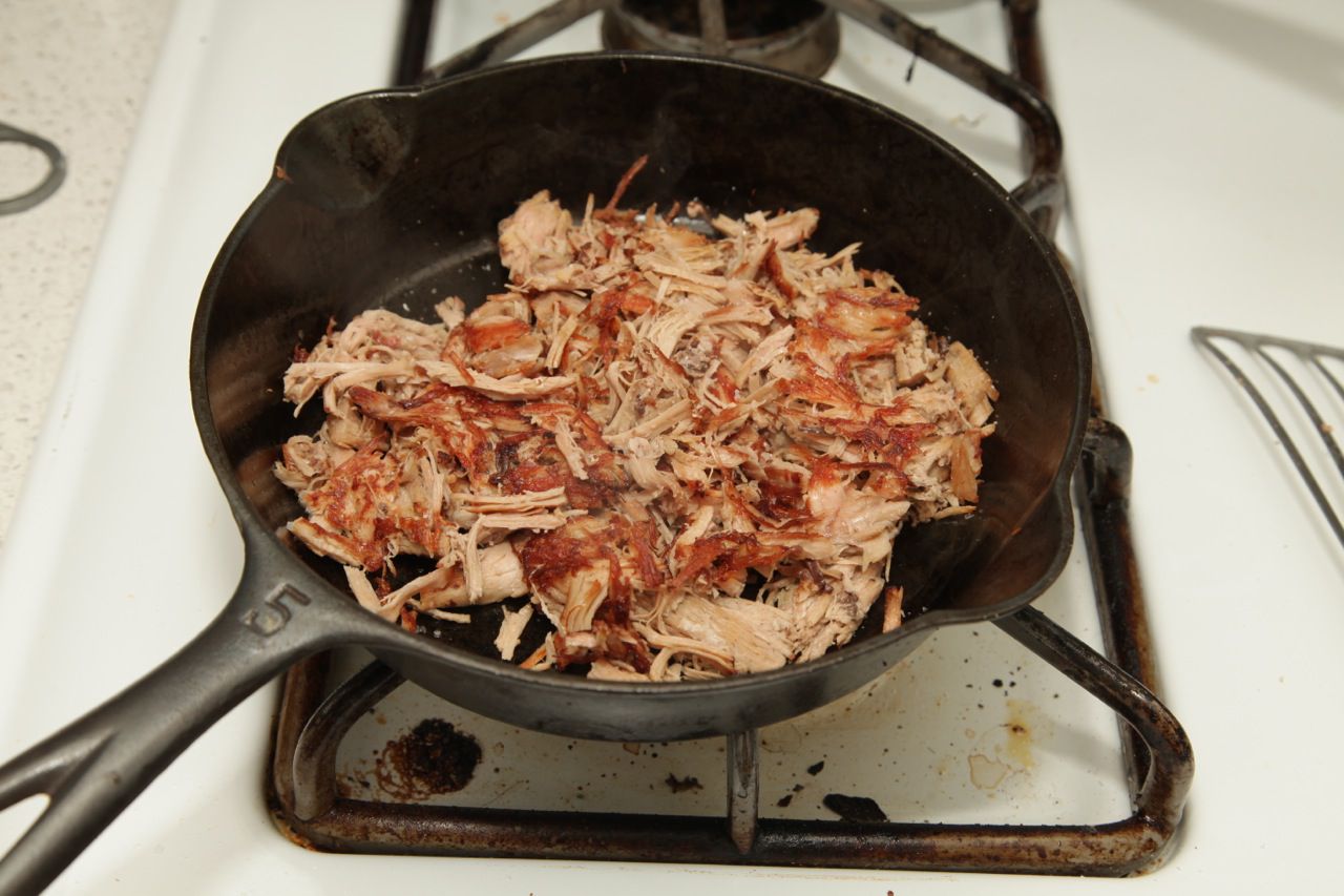 Shredded turkey crisping up in a cast iron skillet. 