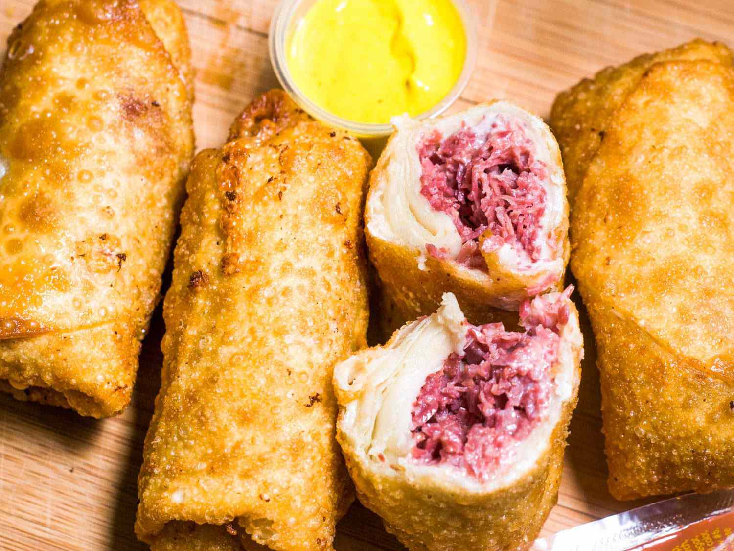 Three corned beef egg rolls and one split in half.