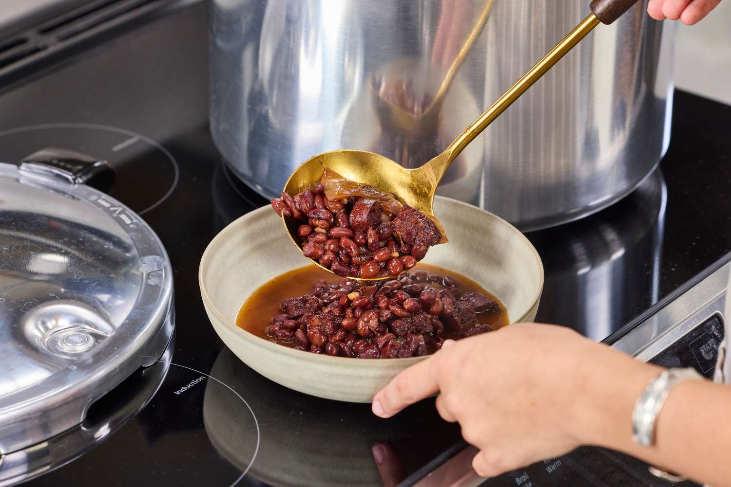 A person serving beans cooked in the Presto 16-Quart Pressure Canner and Cooker
