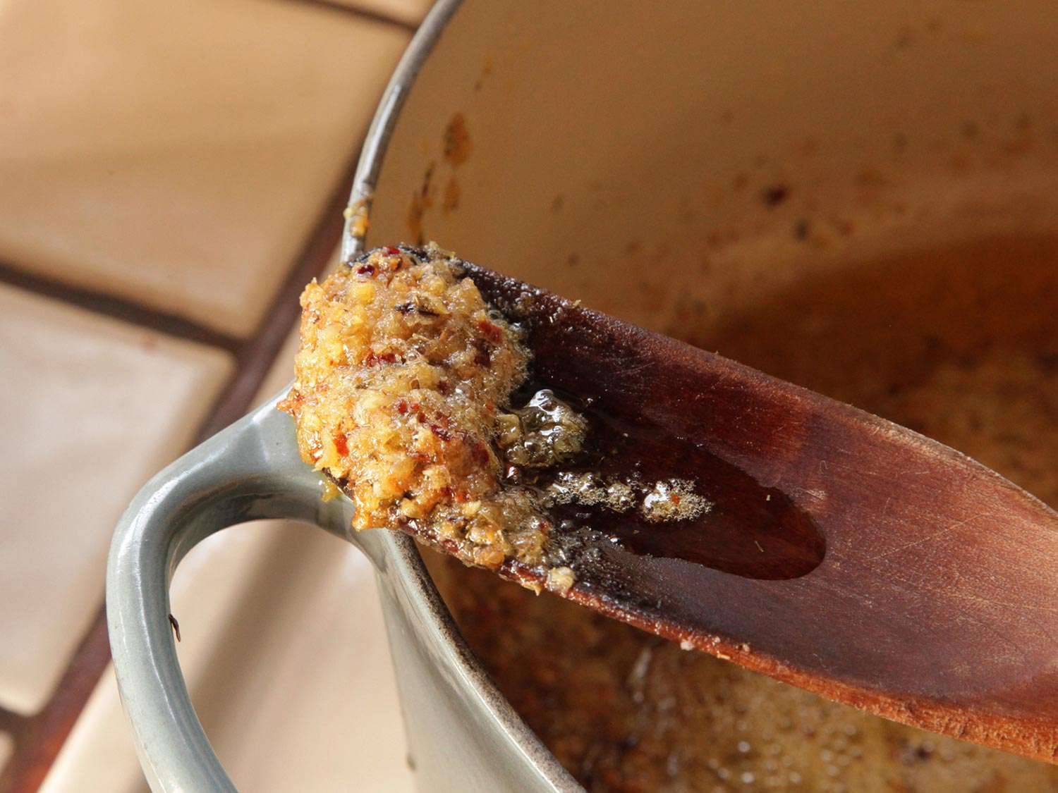 Close-up of slowly browned garlic in wooden spoon