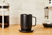 The Ember mug surrounded by coffee making equpiment on a wooden surface