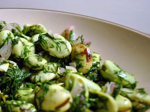 Closeup of broad beans with dill butter.