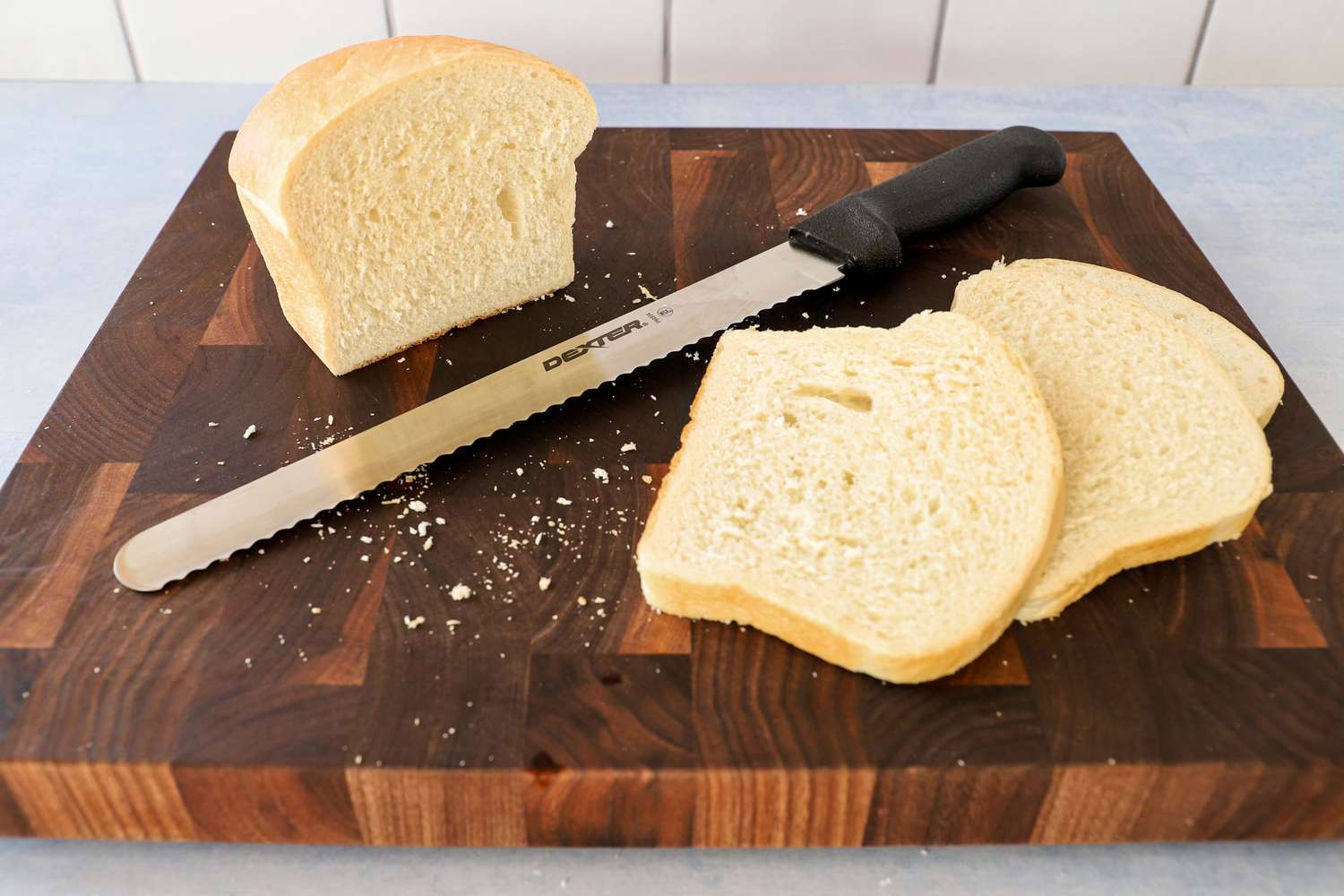Dexter-Russell Basics 10-Inch Bread Knife With Black Polypropylene Handle in between sliced bread