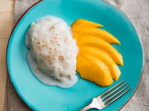 Overhead of coconut sticky rice on a plate with slices of mango